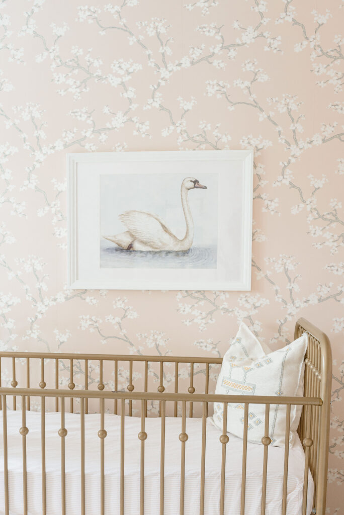 traditional pink baby girl nursery with swan wall art and botanical wallpaper